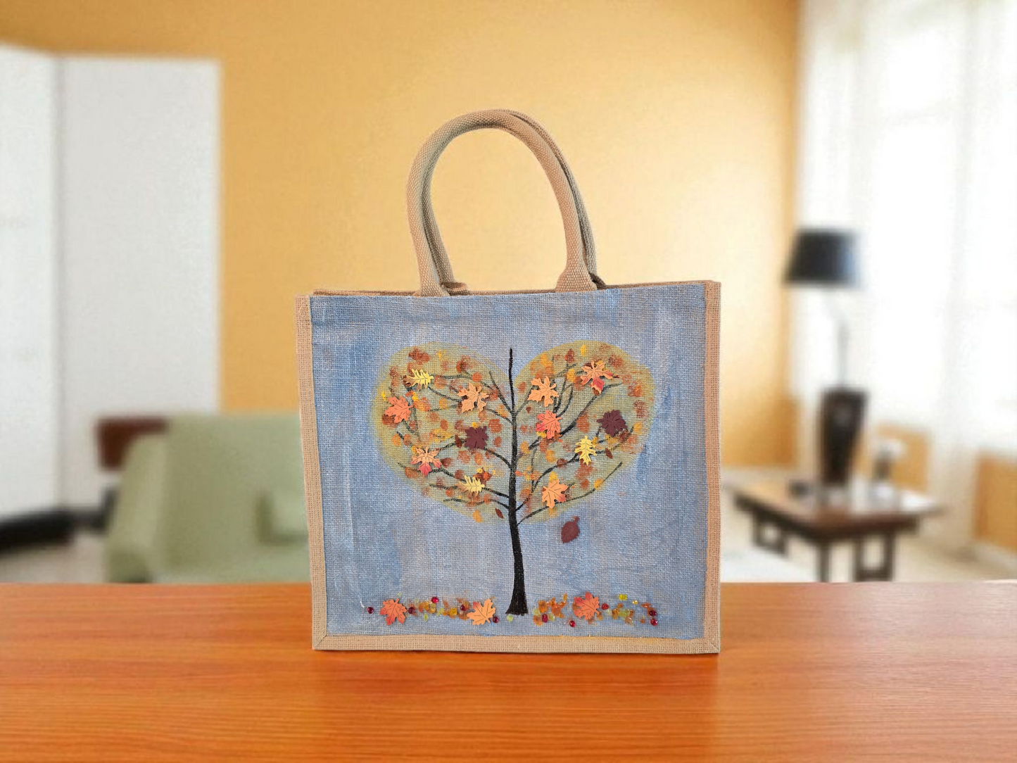 Hand-painted jute tote featuring a heart-shaped fall tree with colorful leaves in red, orange, and gold; painted on a pale blue metallic background with beads and wooden embellishments