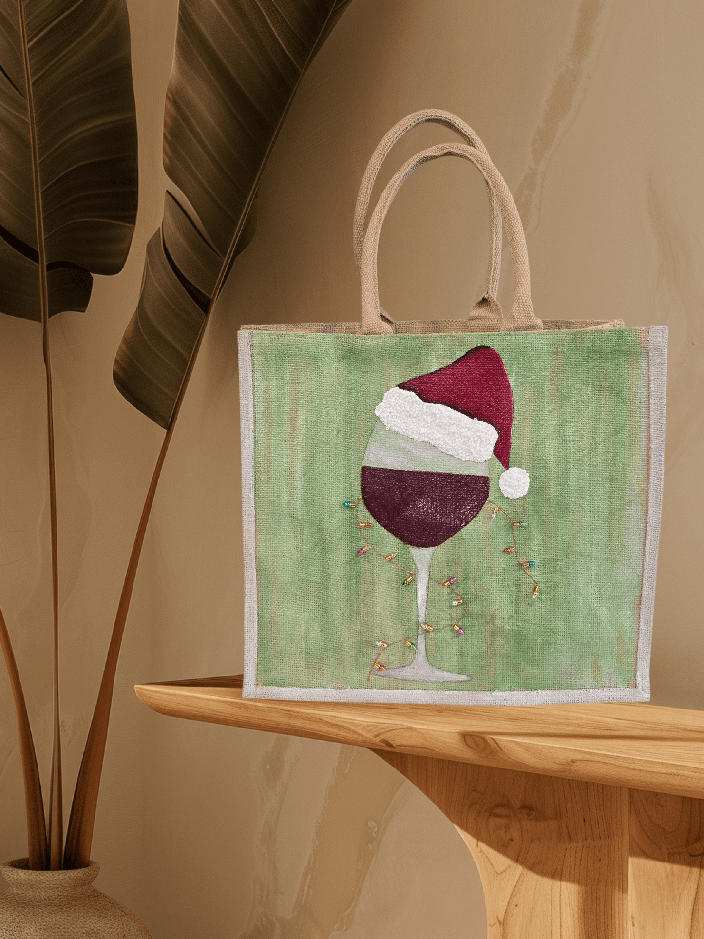 Hand-painted jute tote with a wine glass wearing a Santa hat and tiny holiday lights.