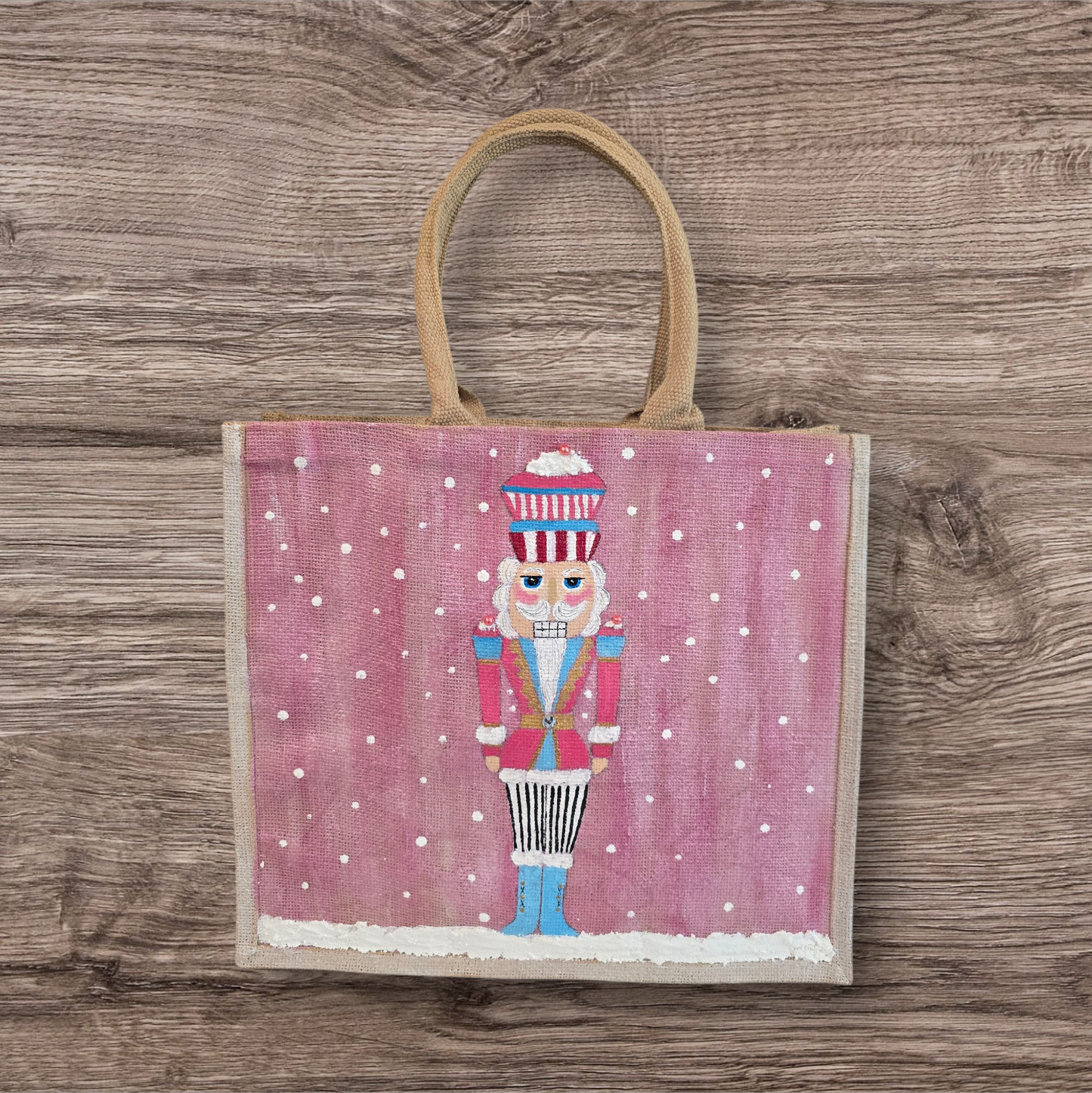 Hand-painted pink Nutcracker on a snowy background, on a jute tote bag.