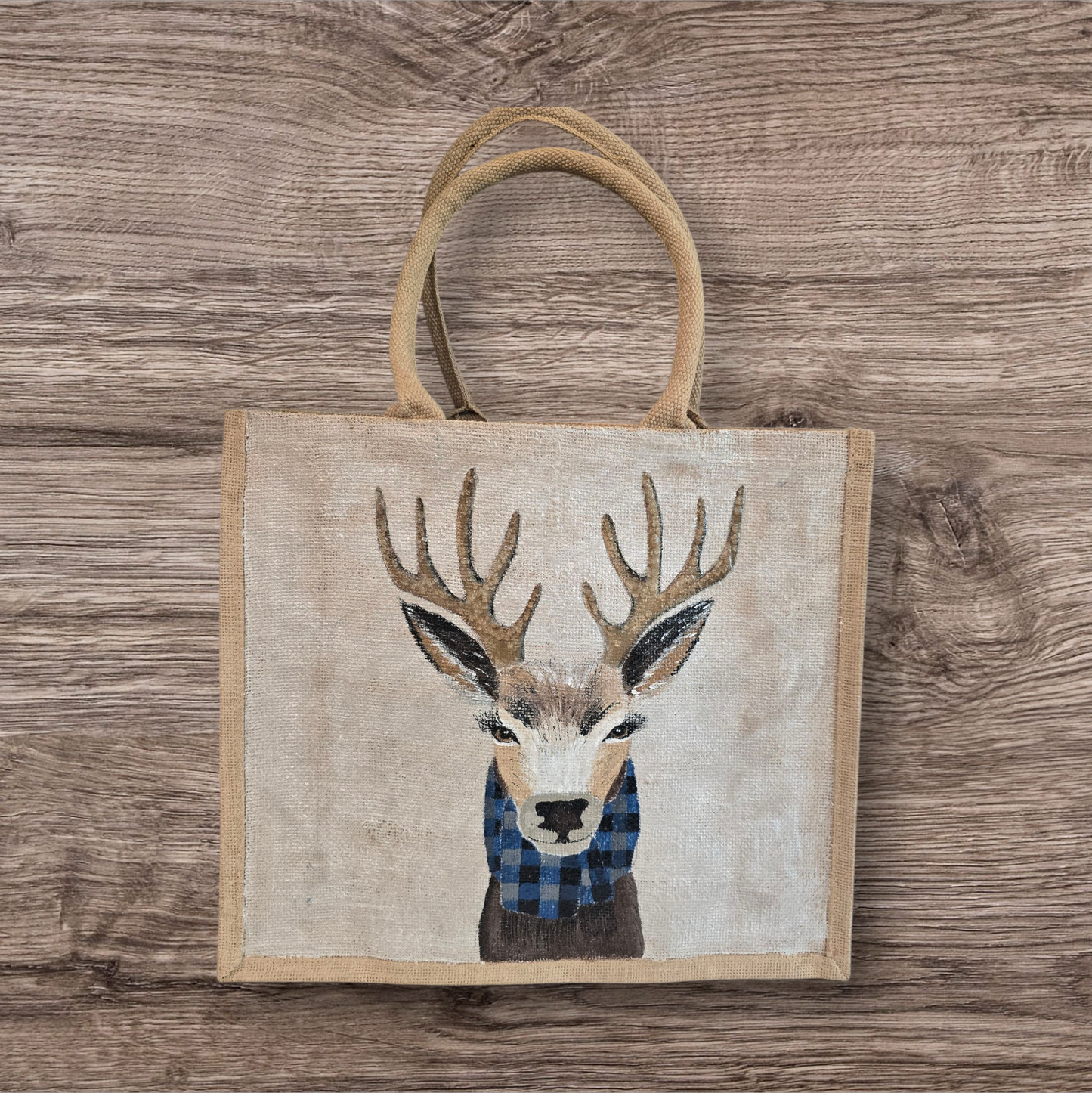 Hand-painted jute tote featuring a reindeer wearing a blue buffalo-plaid scarf.