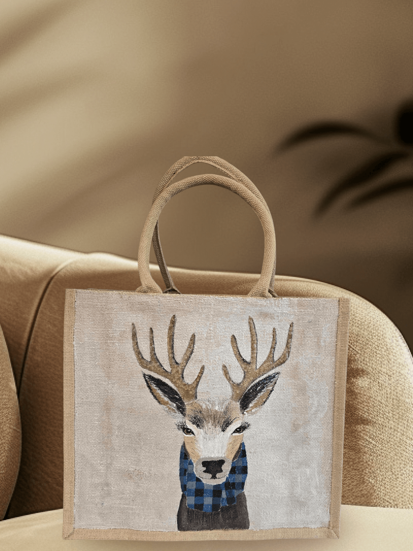 Hand-painted jute tote featuring a reindeer wearing a blue buffalo-plaid scarf.
