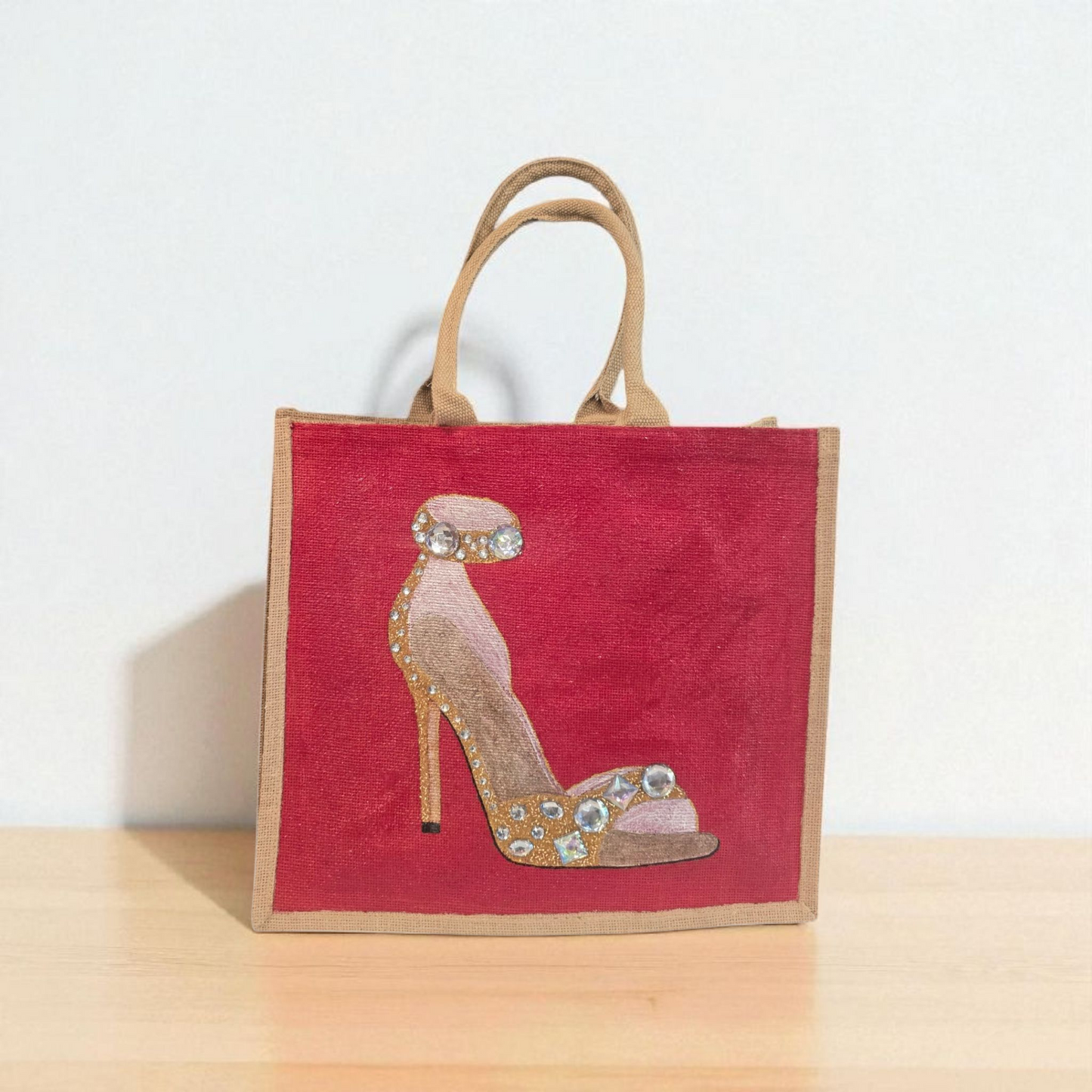Hand-painted gold stiletto tote bag with jeweled accents on natural jute background