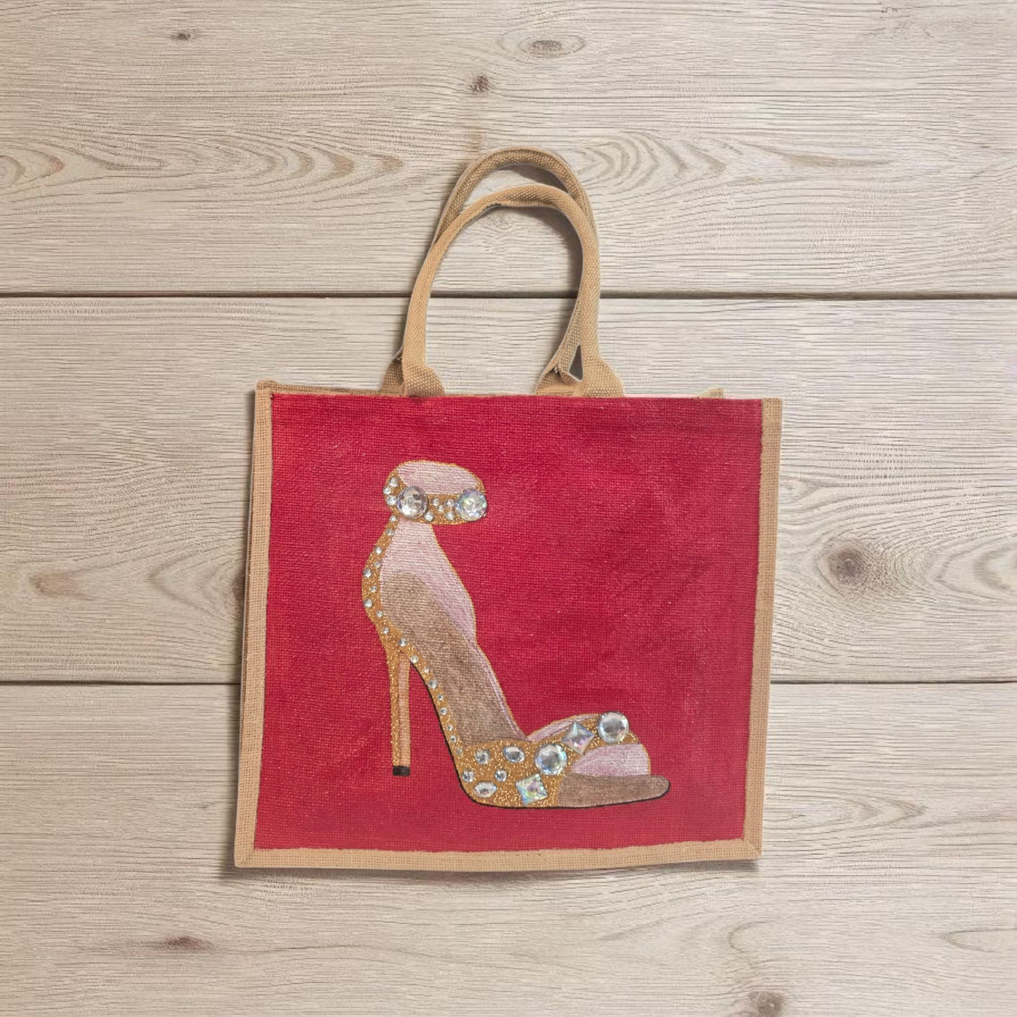 Hand-painted gold stiletto tote bag with jeweled accents on natural jute background