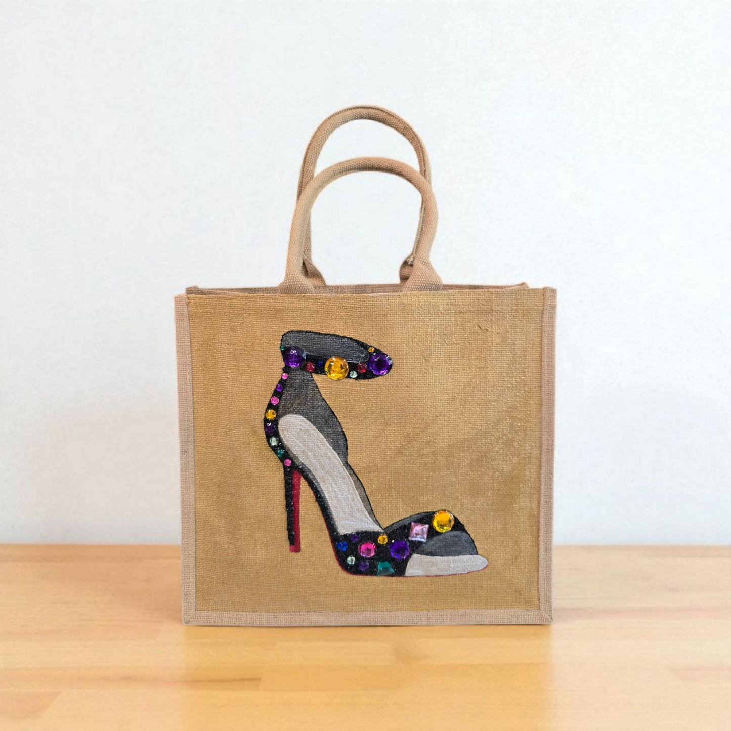Hand-painted black stiletto tote bag with gold jeweled accents on natural jute background