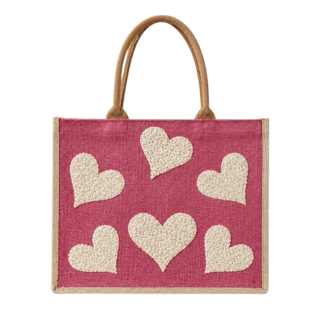 Hand-painted pink jute shopper bag featuring five textured cream hearts on a bright pink background with natural tan handles and trim.