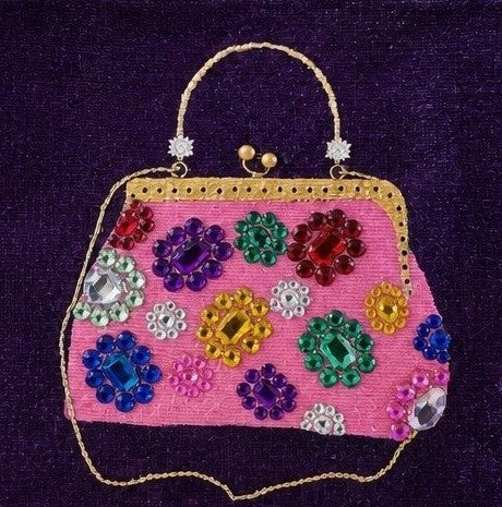 close up of Hand-painted purple jute tote bag featuring an embellished pink vintage-style purse design with colorful jewel accents and dimensional details against a rich purple background. Fashion-inspired statement tote with natural jute trim, double handles, and magnetic snap closure. Perfect for boutique fashion lovers, dressy occasions, and unique handmade gift giving.