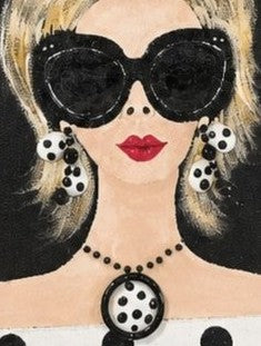 close up of Hand-painted black fringed canvas tote bag featuring a blonde woman wearing oversized sunglasses, polka dot earrings, and a matching polka dot top with dimensional jewelry embellishments.