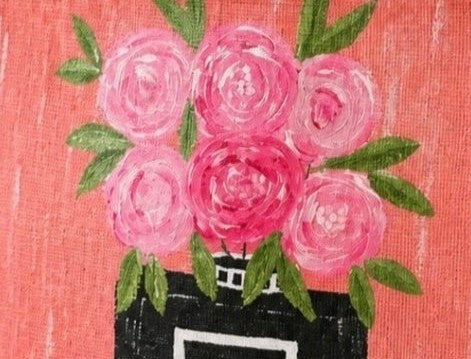 close up of Hand-painted jute tote bag featuring a coral pink background with a black perfume bottle vase filled with pink floral blooms and green leaves. The structured tote has natural woven handles and a feminine, fashion-inspired design with playful boutique-style charm.