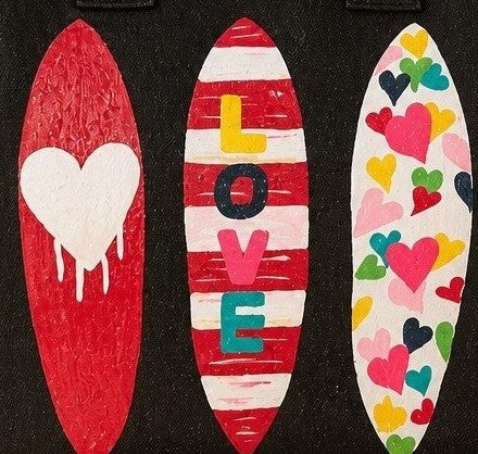 close up of Hand-painted black fringed tote bag featuring three colorful surfboards with heart designs and the word “LOVE,” set against a neutral background.