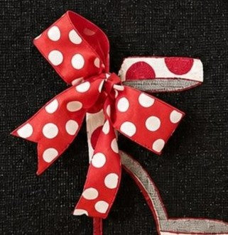 close up of Hand-painted black jute shopper tote featuring a red and white polka dot stiletto shoe with a matching dimensional ribbon bow, designed as bold wearable fashion art.