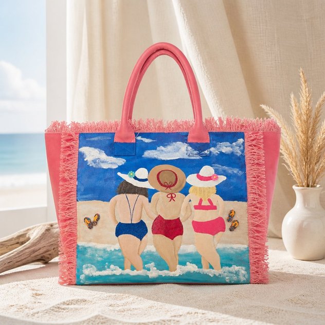 Hand-painted pink fringed tote bag featuring three women walking into the ocean in colorful swimsuits and sun hats, with a beach scene, blue sky, clouds, and flip-flop details on a vibrant coastal-inspired design.