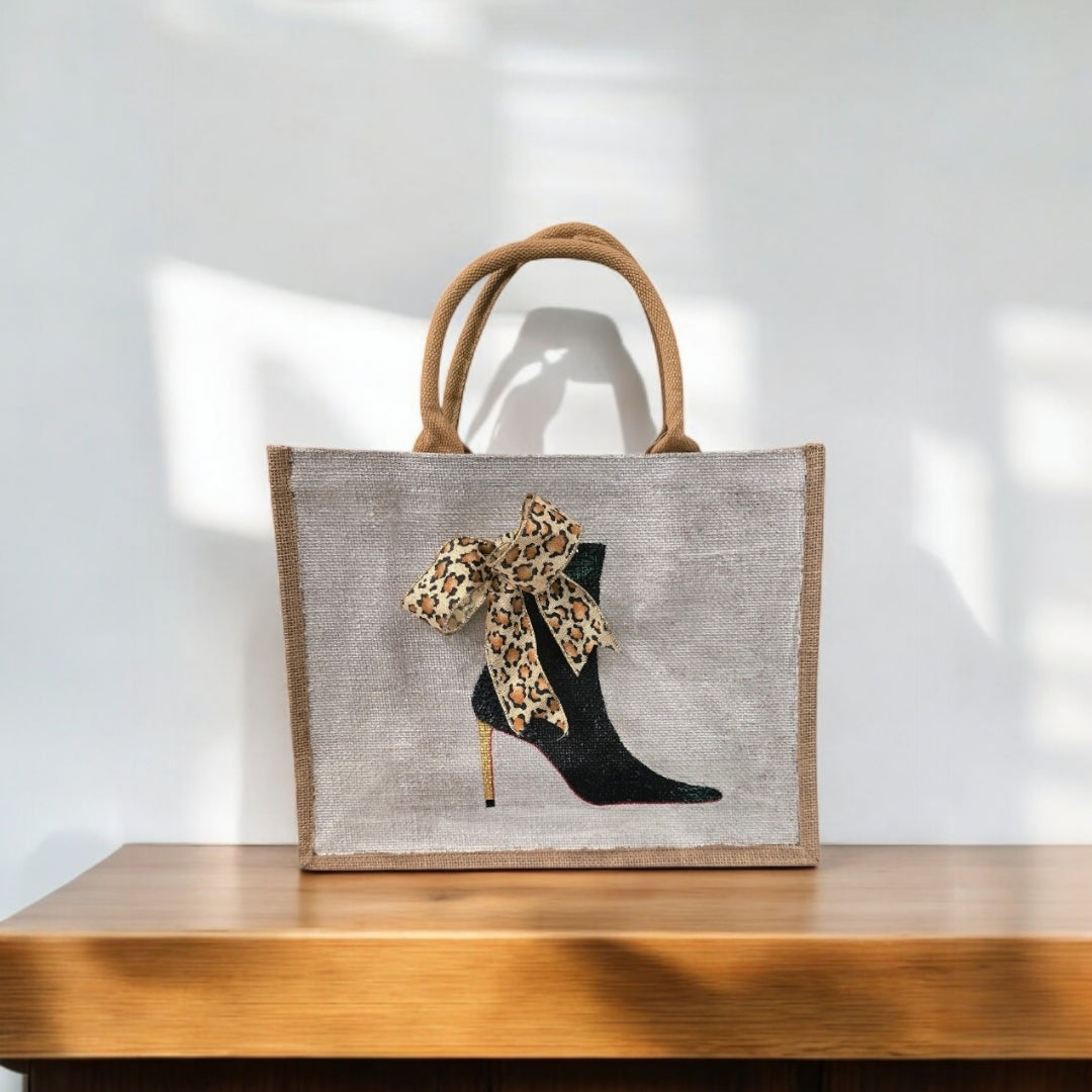 Off white jute tote bag with hand-painted black booties and red soles, featuring beaded embellishments.