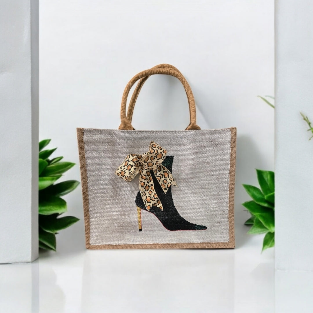 Off white jute tote bag with hand-painted black booties and red soles, featuring beaded embellishments.
