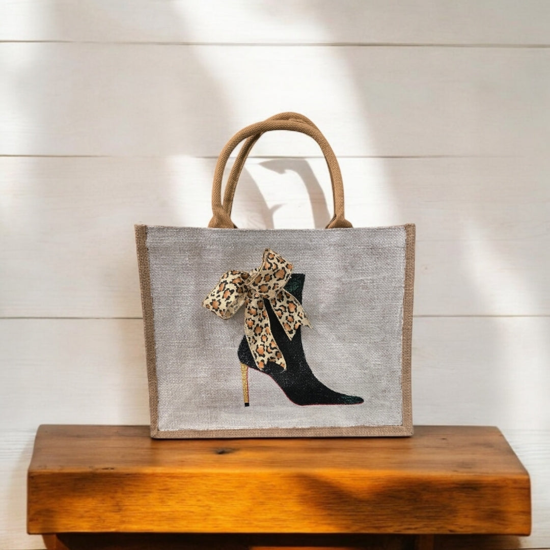 Off white jute tote bag with hand-painted black booties and red soles, featuring beaded embellishments.