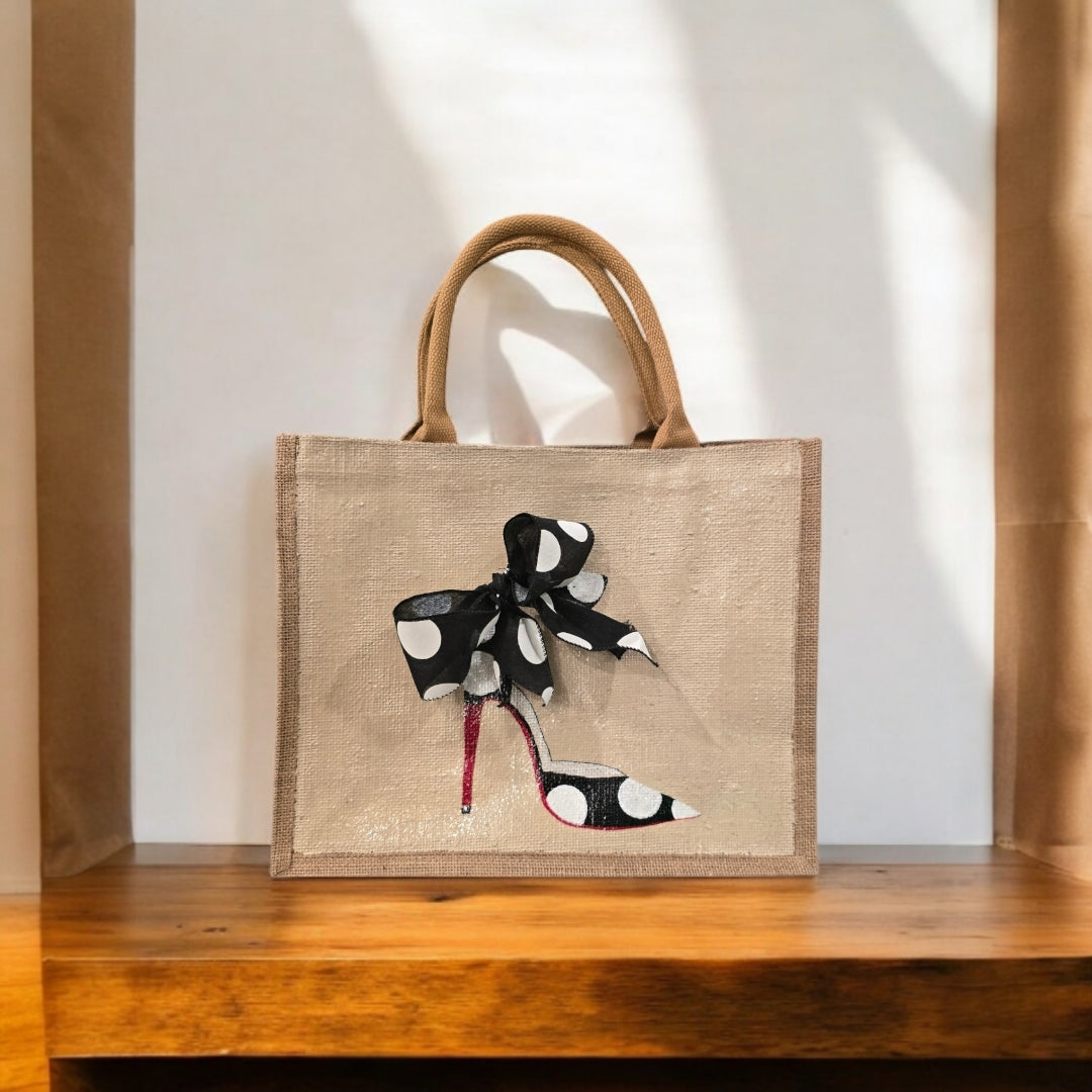 Off white jute tote bag with hand-painted black stilettos, white polka dots, red soles, and beaded accents.