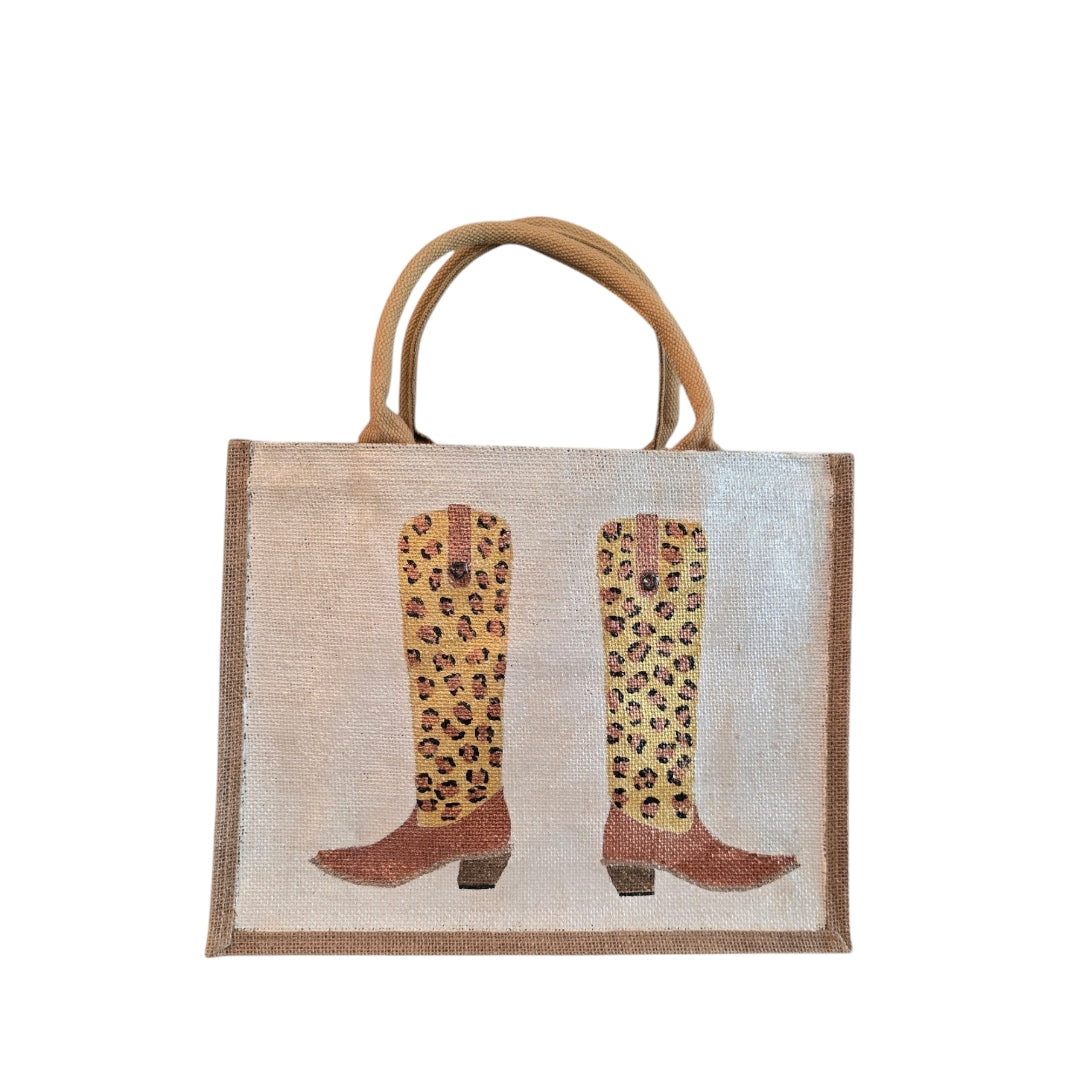 Off white jute tote bag with hand-painted leopard print cowboy boots, detailed with bead accents.