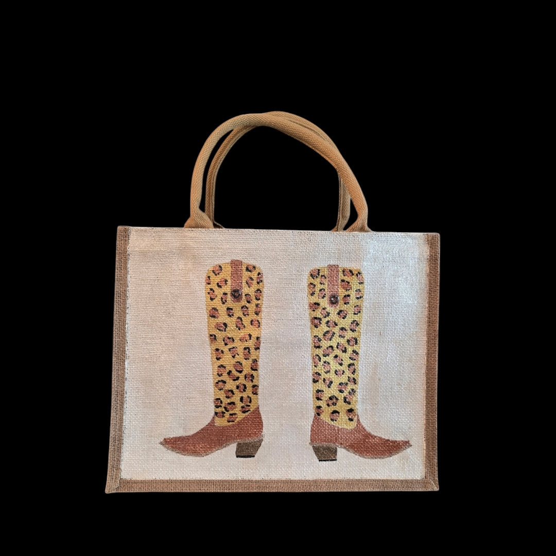 Off white jute tote bag with hand-painted leopard print cowboy boots, detailed with bead accents.