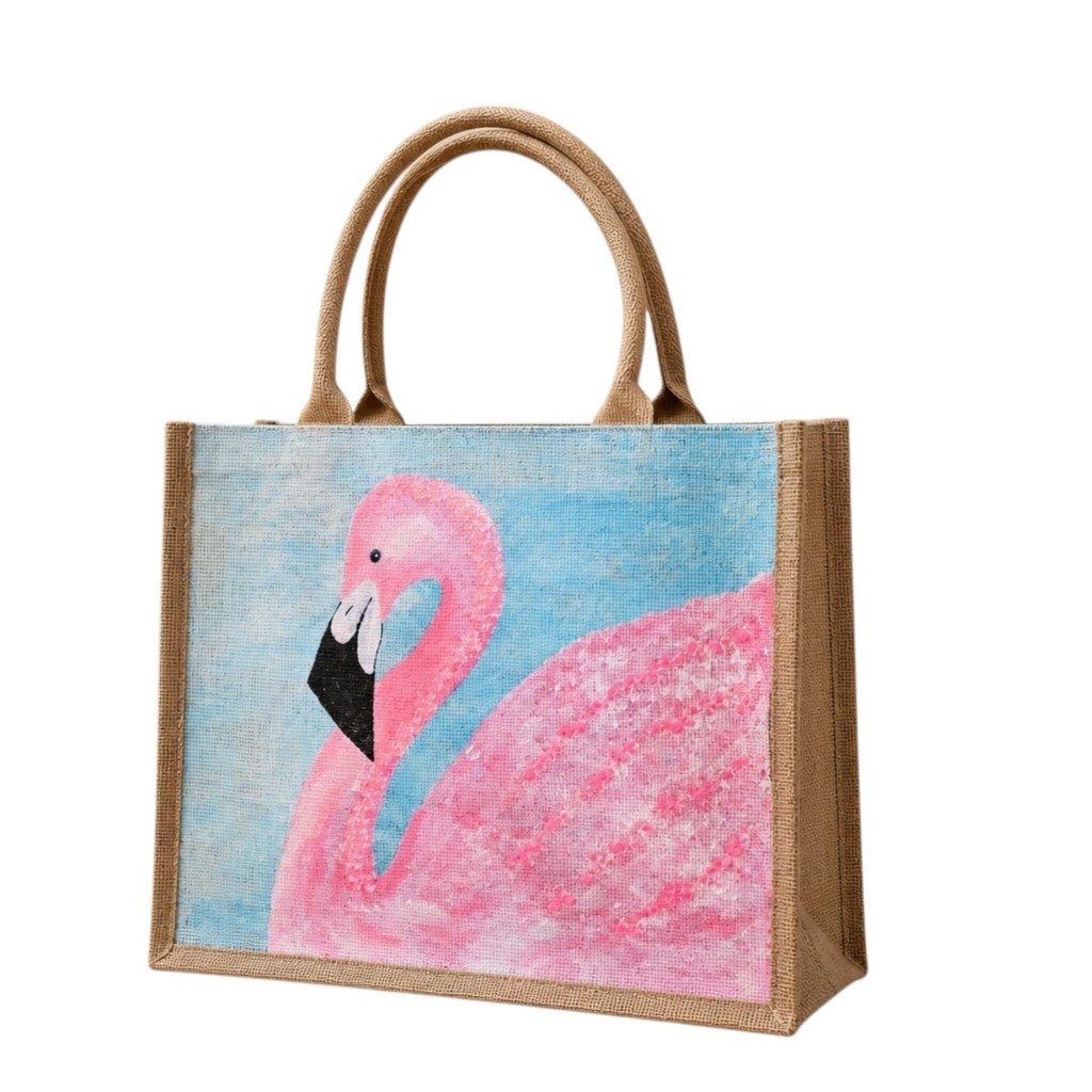 Hand-painted flamingo tote bag on natural jute canvas featuring a large pink flamingo against a soft blue background, finished with sturdy double handles and a structured rectangular silhouette.
