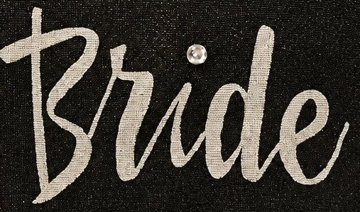 close up of Hand-painted black jute tote bag featuring the word “Bride” in bold white script with a rhinestone accent, designed for weddings, bridal celebrations, and stylish bride-to-be gifts.