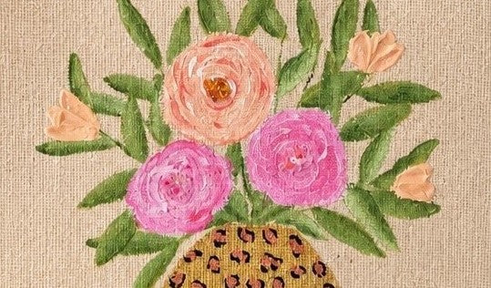 close up of Hand-painted natural jute tote bag featuring a floral arrangement of pink and peach blooms with green leaves in a leopard-print vase. The structured tote has natural woven handles and a warm neutral palette that blends feminine floral charm with trendy animal-print accents.