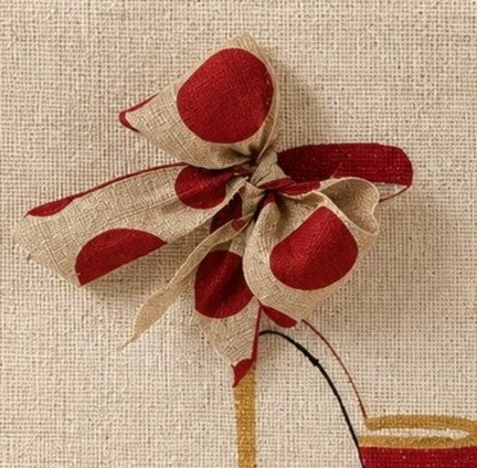 close up of Hand-painted jute tote bag featuring a red high heel shoe design with an oversized red and natural polka dot bow detail. Neutral canvas-style tote with structured handles and fashion-inspired artwork on a light textured background.