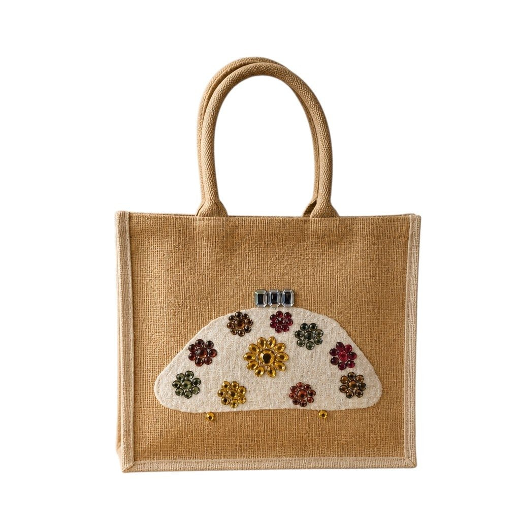 Hand-painted natural jute tote bag featuring a white half-moon purse design embellished with colorful jewel-like floral accents in gold, red, green, and amber tones. The structured tote has rounded woven handles and a neutral background, giving it an elegant artisan-inspired look.