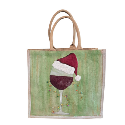 Hand-painted jute tote with a wine glass wearing a Santa hat and tiny holiday lights.