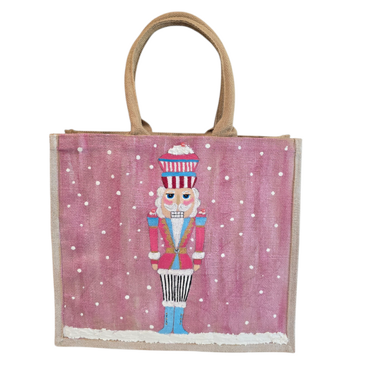 Hand-painted pink Nutcracker on a snowy background, on a jute tote bag.