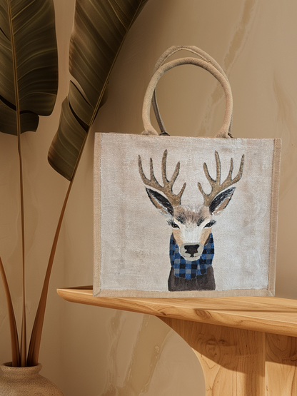 Hand-painted jute tote featuring a reindeer wearing a blue buffalo-plaid scarf.