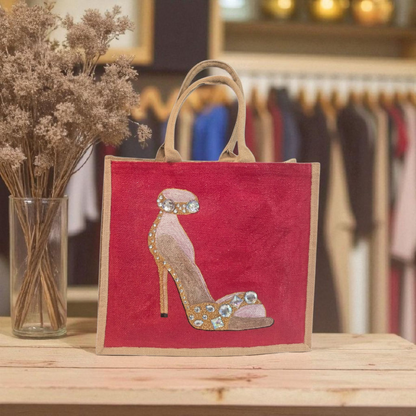 Hand-painted gold stiletto tote bag with jeweled accents on natural jute background