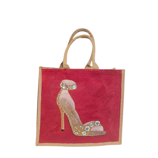 Hand-painted gold stiletto tote bag with jeweled accents on natural jute background