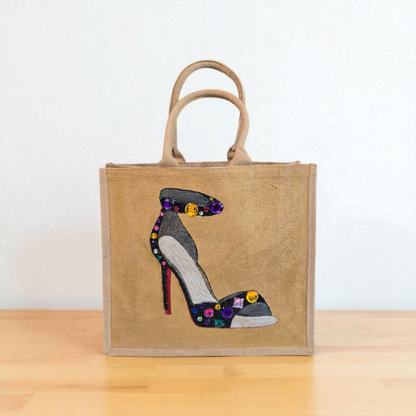 Hand-painted black stiletto tote bag with gold jeweled accents on natural jute background