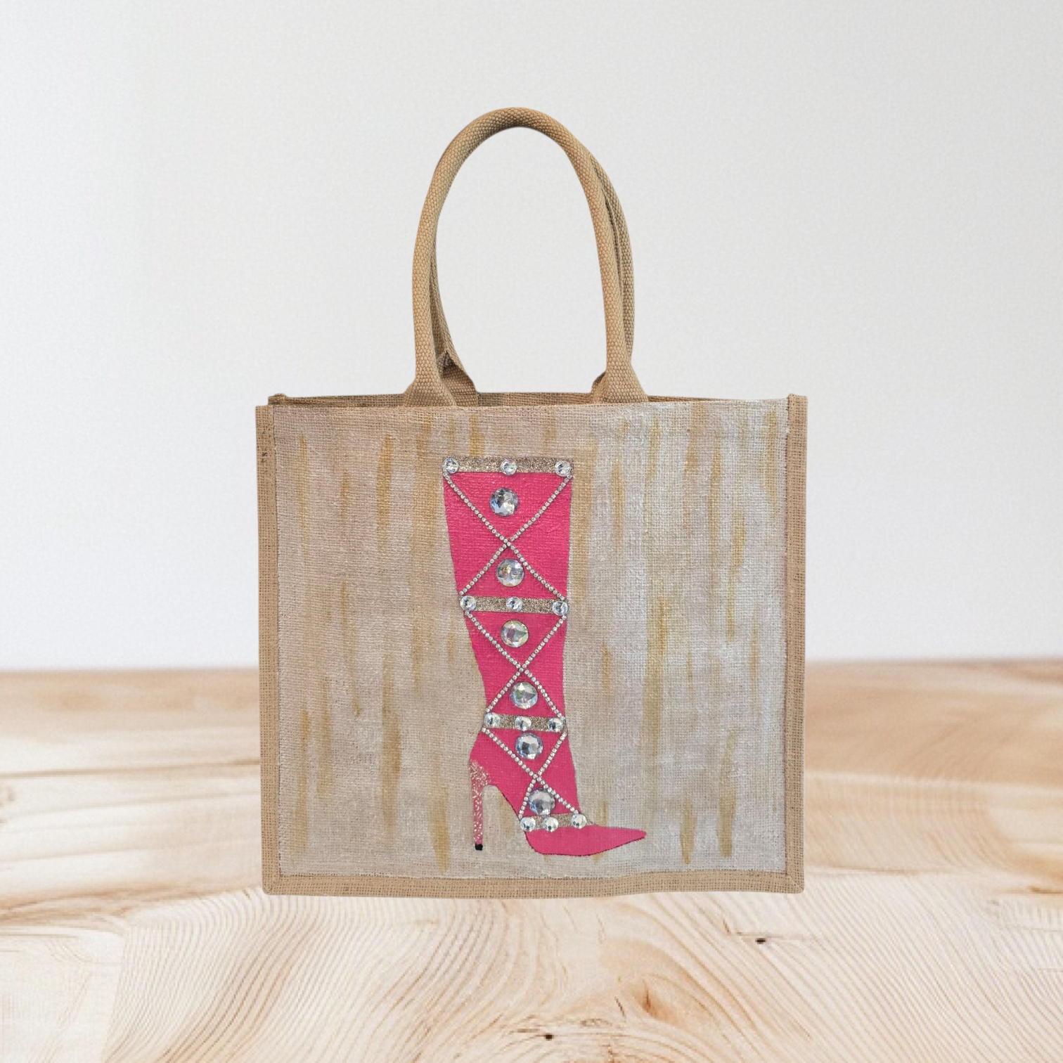 Hand-painted pink rhinestone boot tote bag on natural jute background