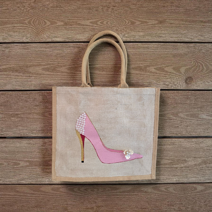 Pink Stiletto hand painted on jute tote bag embellished with jewels and pearls on an off white metallic background.