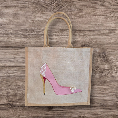 Pink Stiletto hand painted on jute tote bag embellished with jewels and pearls on an off white metallic background.