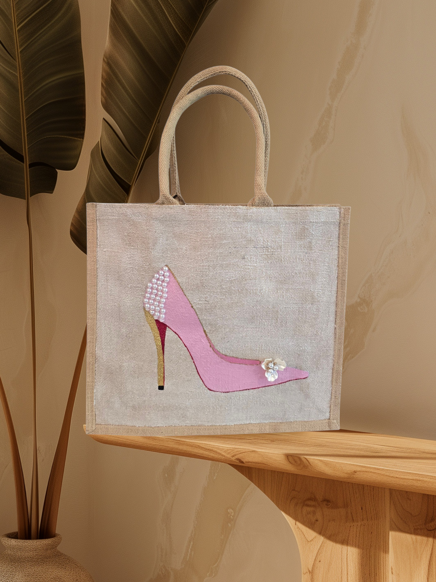 Pink Stiletto hand painted on jute tote bag embellished with jewels and pearls on an off white metallic background.