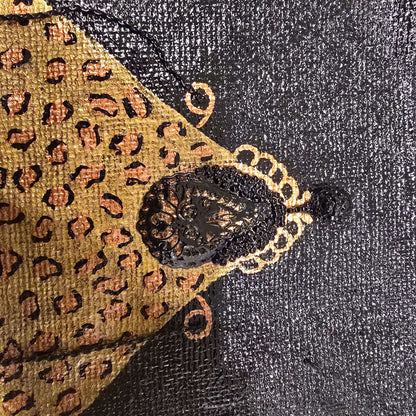 close up of Hand-painted black jute purse tote with gold leopard design and chain handles