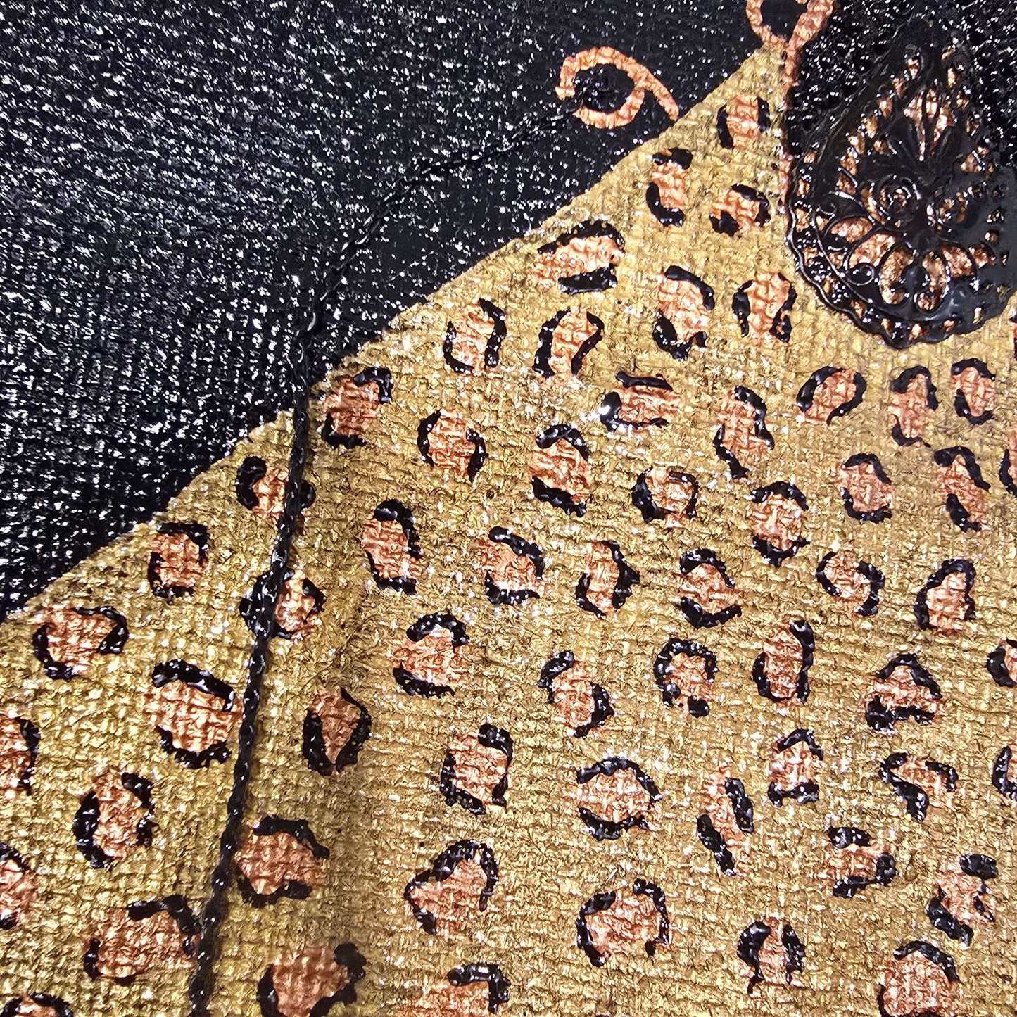 close up of Hand-painted black jute purse tote with gold leopard design and chain handles 