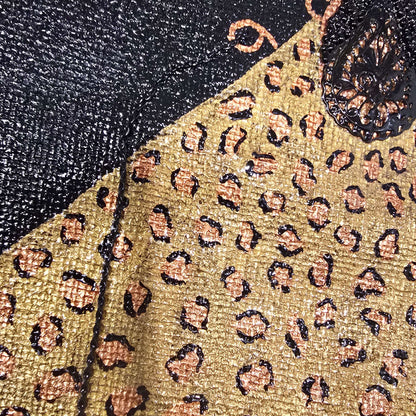 close up of Hand-painted black jute purse tote with gold leopard design and chain handles 