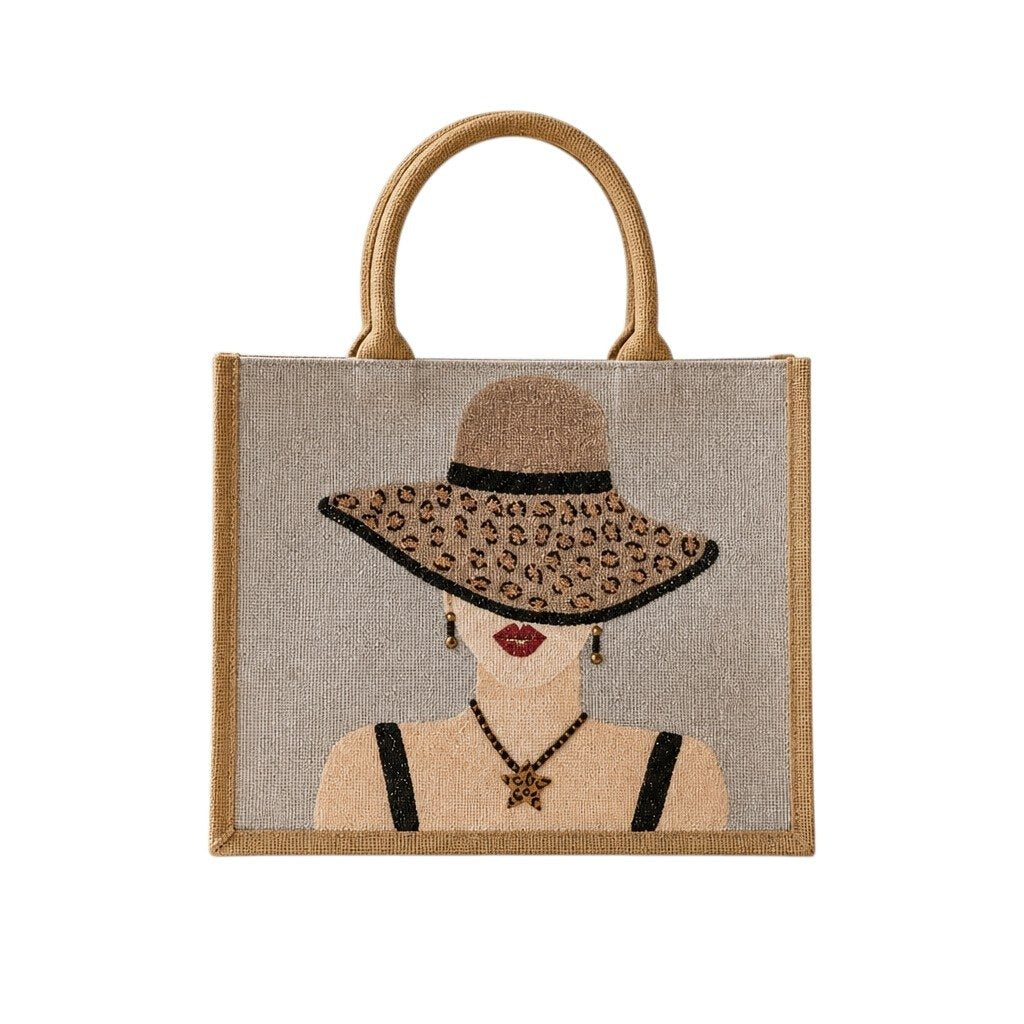 Hand-painted neutral jute tote bag featuring a stylish woman in a leopard-print sun hat with black straps, red lips, statement earrings, and natural woven handles.