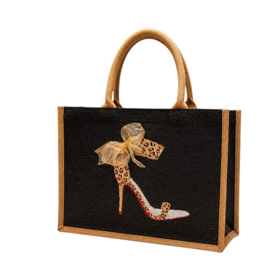 Hand-painted black jute tote bag featuring a leopard print high heel stiletto with a sheer gold bow, red sole accents, and natural jute trim and handles for a bold fashion-inspired look