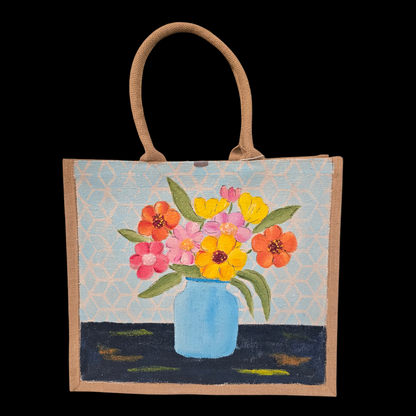 Hand-painted jute tote bag featuring colorful flowers in a blue vase against a light patterned background