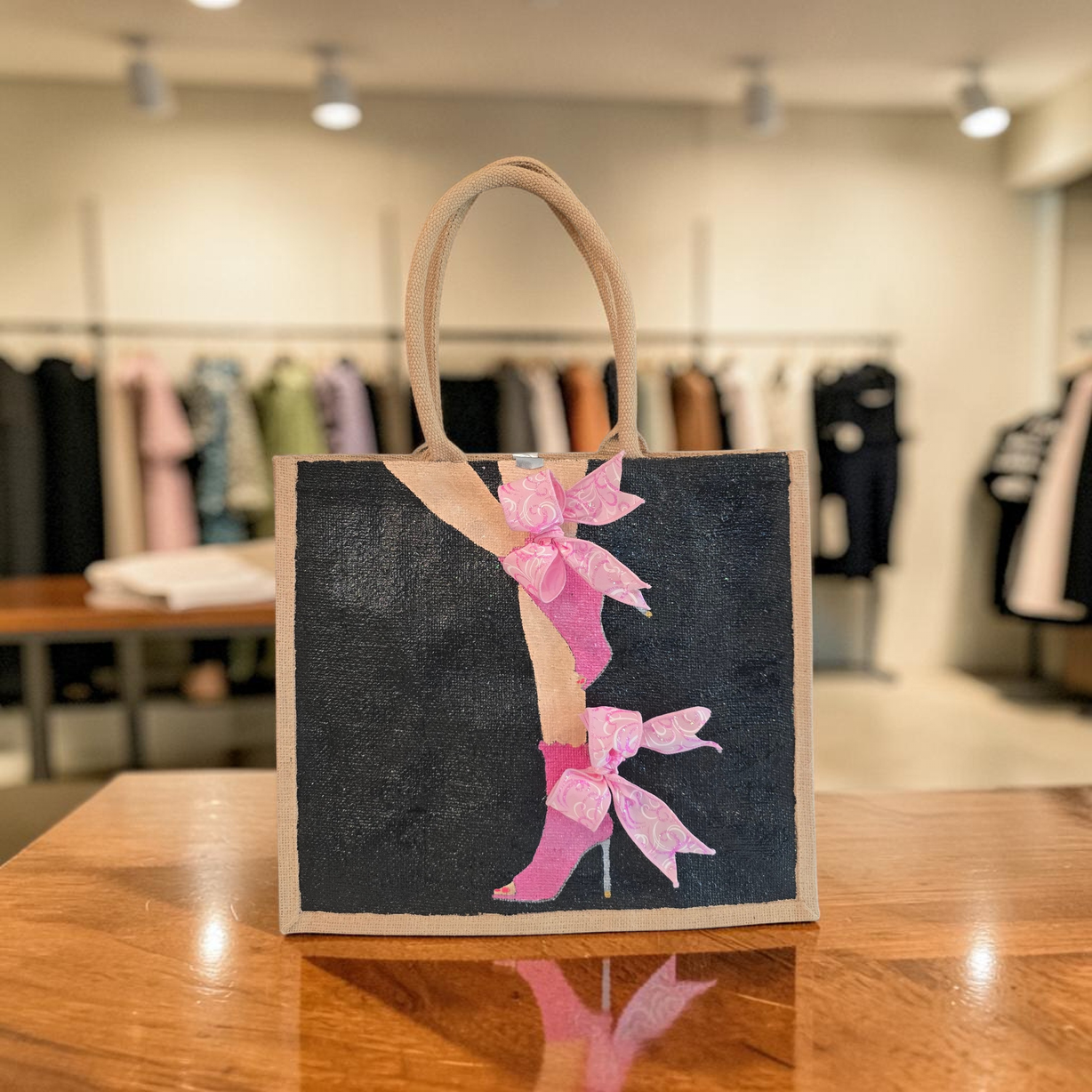 Hand-painted tote bag featuring a pink high heel with bows on a black background with dimensional ribbon accents