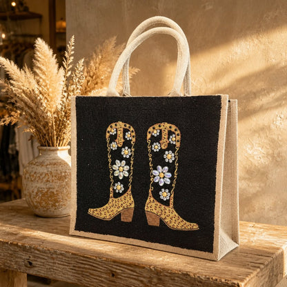 Black and gold jeweled cowboy boots hand-painted on a jute tote bag with crystal floral embellishments