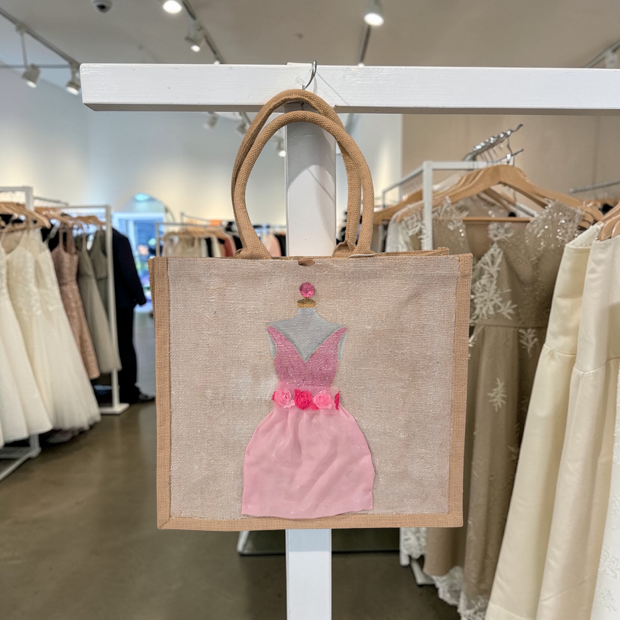 Hand-painted jute tote bag featuring a blush pink bridesmaid dress with floral details on a natural canvas background