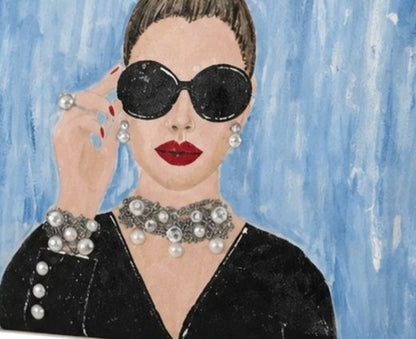 Hand-painted fringed tote bag featuring a glamorous woman with oversized black sunglasses, red lipstick, pearl jewelry, and an elegant updo against a soft blue background on a cream canvas tote.