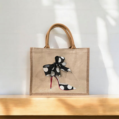 Off white jute tote bag with hand-painted black stilettos, white polka dots, red soles, and beaded accents.