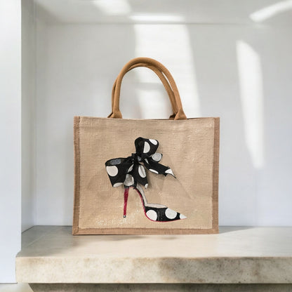 Off white jute tote bag with hand-painted black stilettos, white polka dots, red soles, and beaded accents.