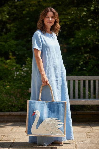 woman holding Hand Painted and embellished white swan tote bag by Dana's Uncommon Glass