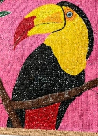 Close up of Hand-painted jute tote bag featuring a colorful toucan perched on a branch against a bright pink background, with natural burlap sides and handles.